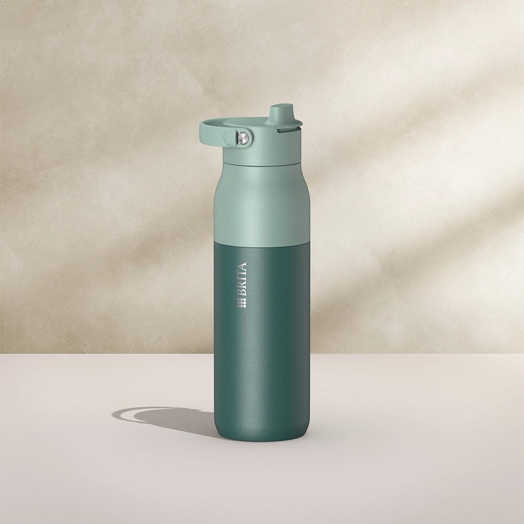Botella BRITA LARQ Essential de 1000 ml, de color verde sobre fondo beige.