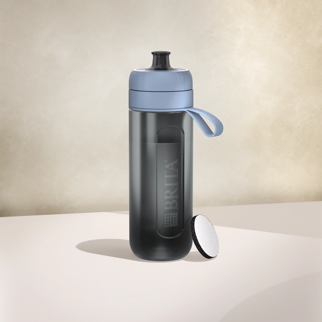 Botella filtrante BRITA Active de color azul oscuro sobre un fondo beige